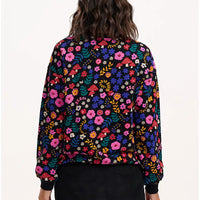 Person wearing a colorful floral-patterned jacket on a white background