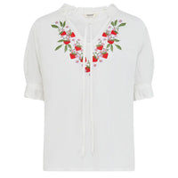 White blouse with floral embroidery on a white background