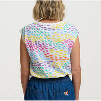 Person wearing a colorful sleeveless top with a white background
