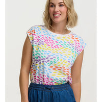 Woman wearing a colorful patterned top with a plain background
