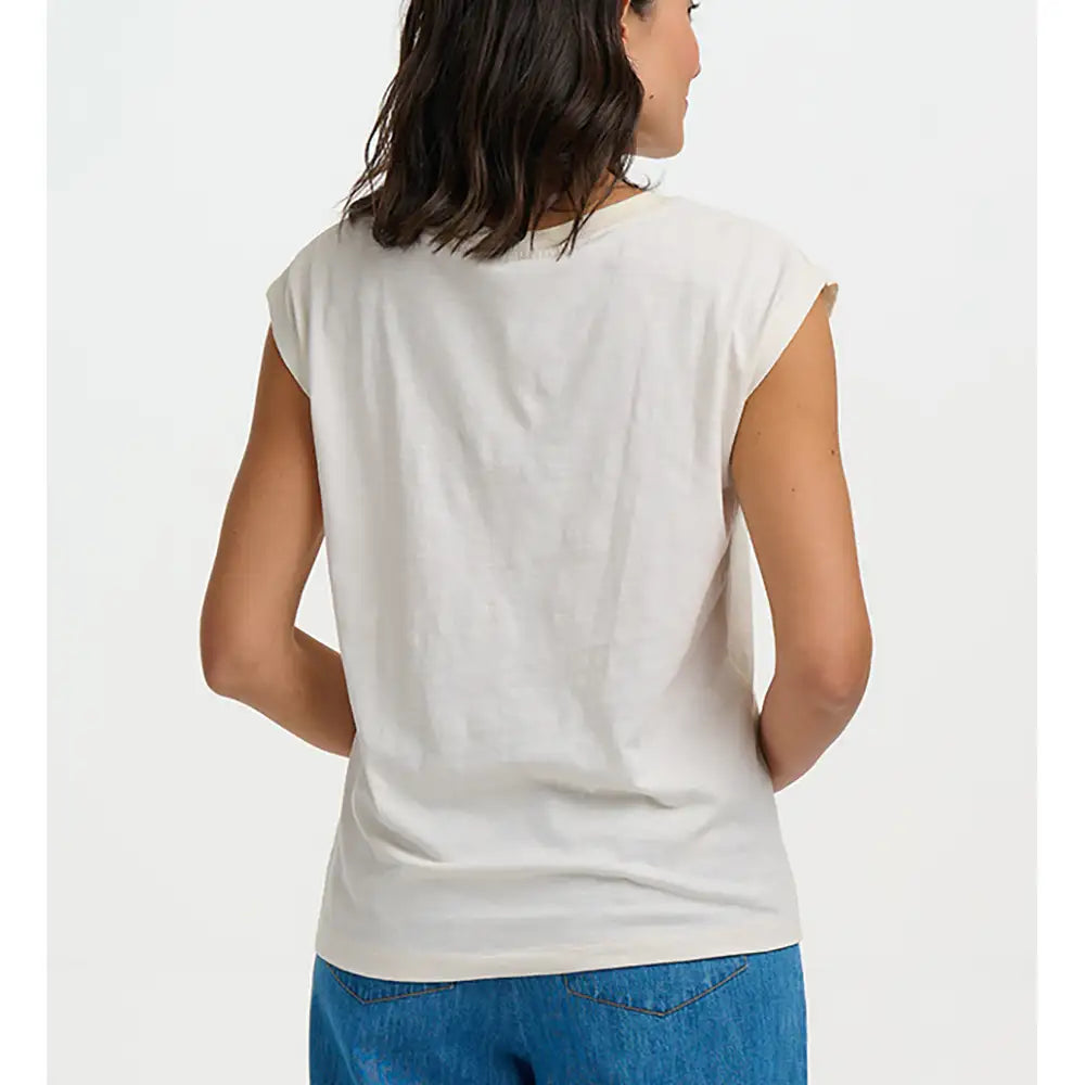 Woman wearing a white sleeveless top and blue jeans on a white background