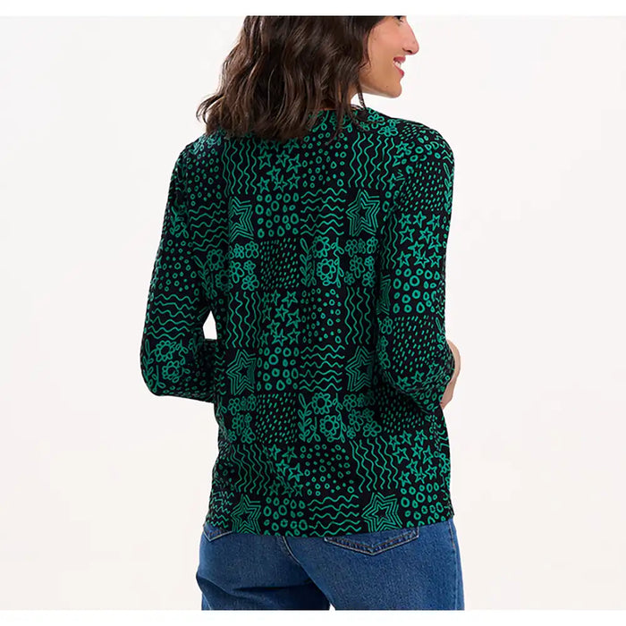 Woman wearing a green patterned shirt on a white background