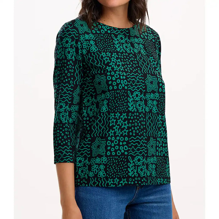 Person wearing a green patterned top on a white background