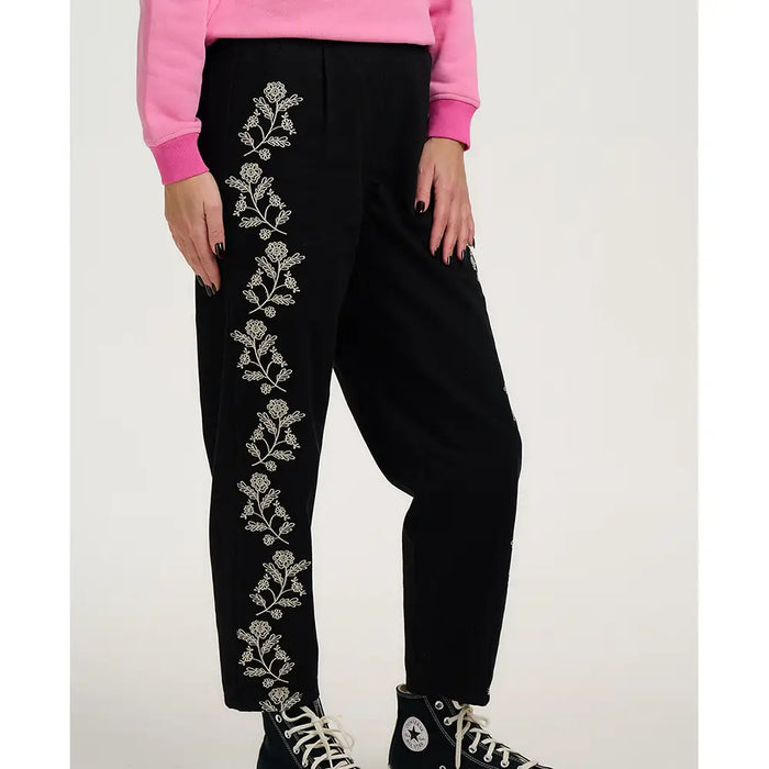 Black pants with floral embroidery on a white background