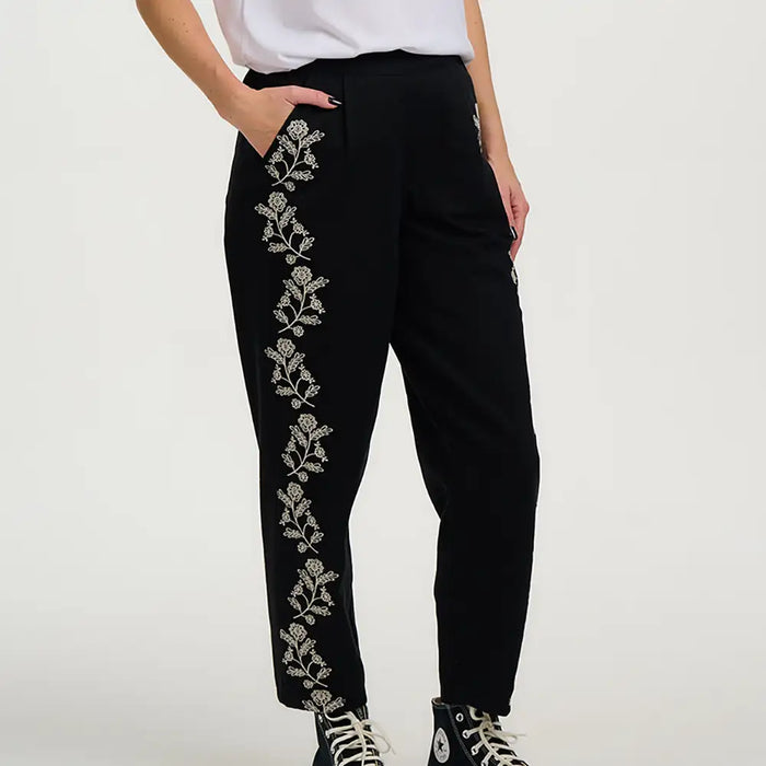 Black pants with floral embroidery on a white background