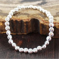 Silver beaded bracelet on a wooden surface
