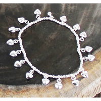 Silver bracelet with heart-shaped charms on a dark wooden surface