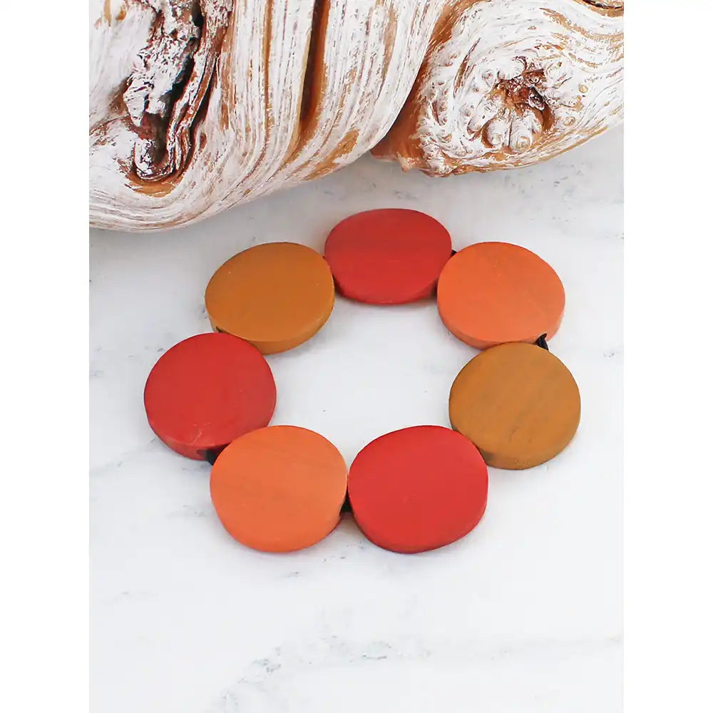 Colorful circular objects on a white surface with bread in the background