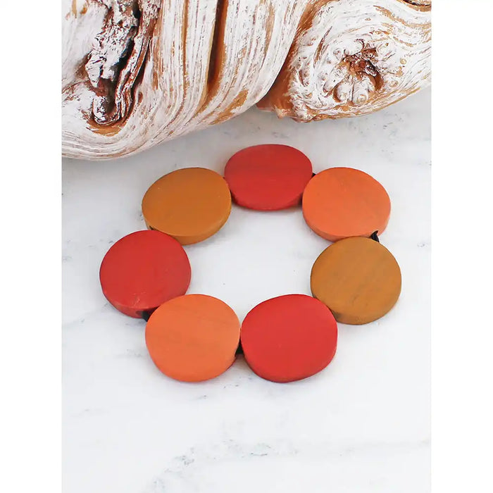 Colorful circular objects on a white surface with bread in the background