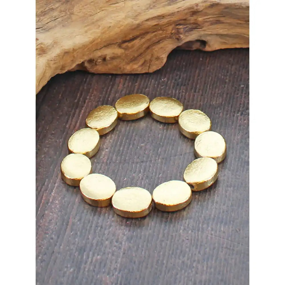 Gold bracelet on a wooden surface