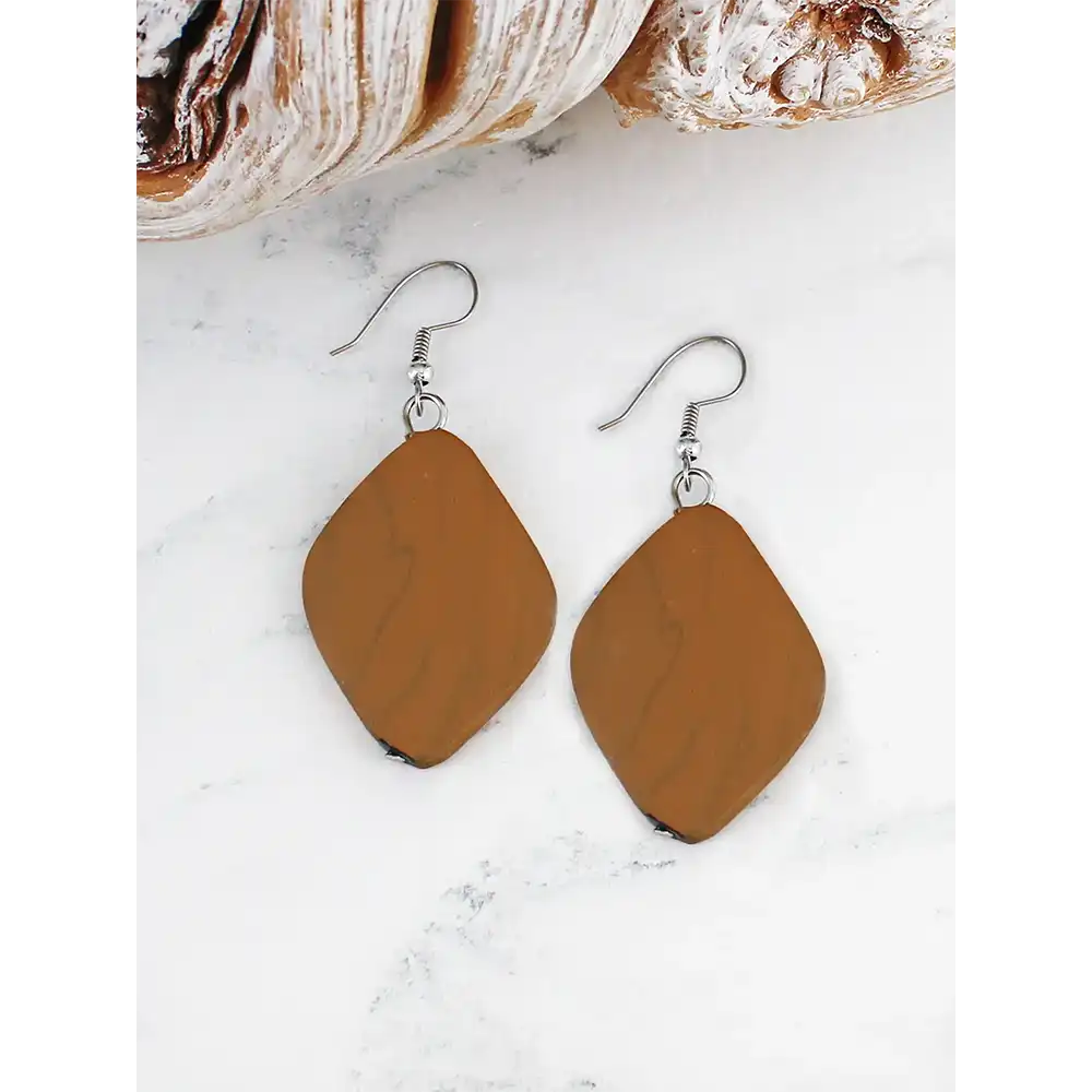 Brown teardrop earrings on a white marble surface