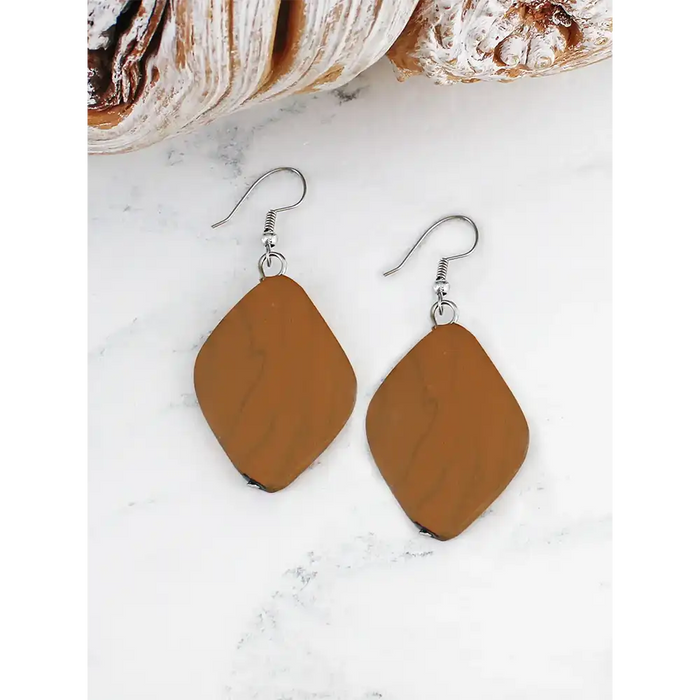 Brown teardrop earrings on a white marble surface
