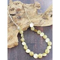 Necklace with gold and silver beads on a wooden surface