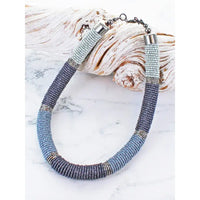 Beaded necklace with silver accents on a textured surface