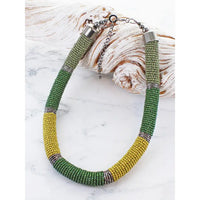 Beaded bracelet with green and yellow pattern on a white background