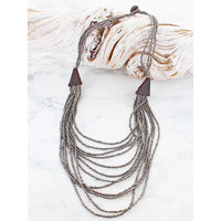 Necklace with layered beads and wooden accents on a white background