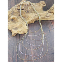 Set of gold necklaces on a wooden surface
