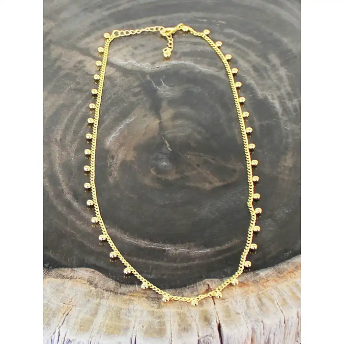 Gold necklace on a wooden surface