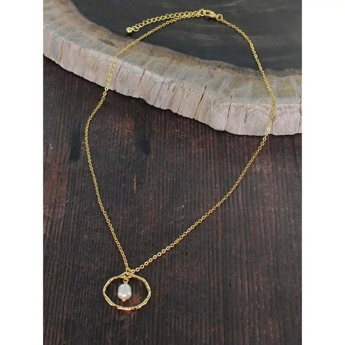 Gold necklace with a pendant on a wooden surface