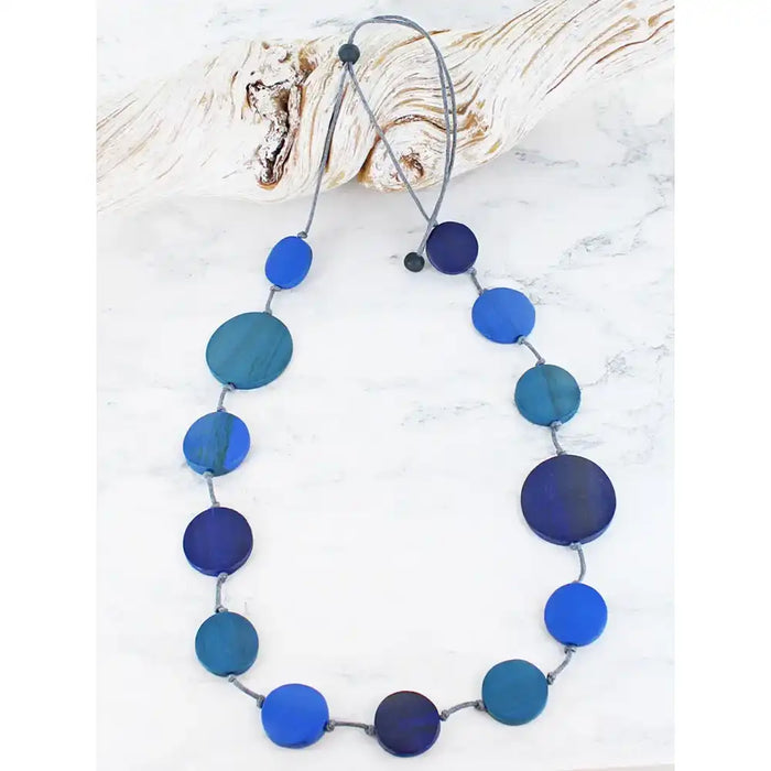 Necklace with blue and green circular beads on a white background