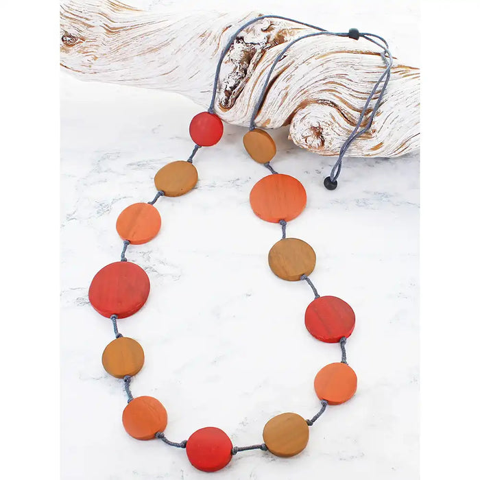 Necklace with red and brown circular beads on a white background