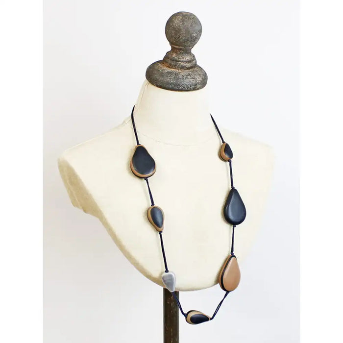 Long necklace with resin black and brown beads on black cord, on a mannequin neck. 