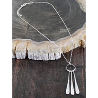Silver necklace with a pendant on a wooden surface