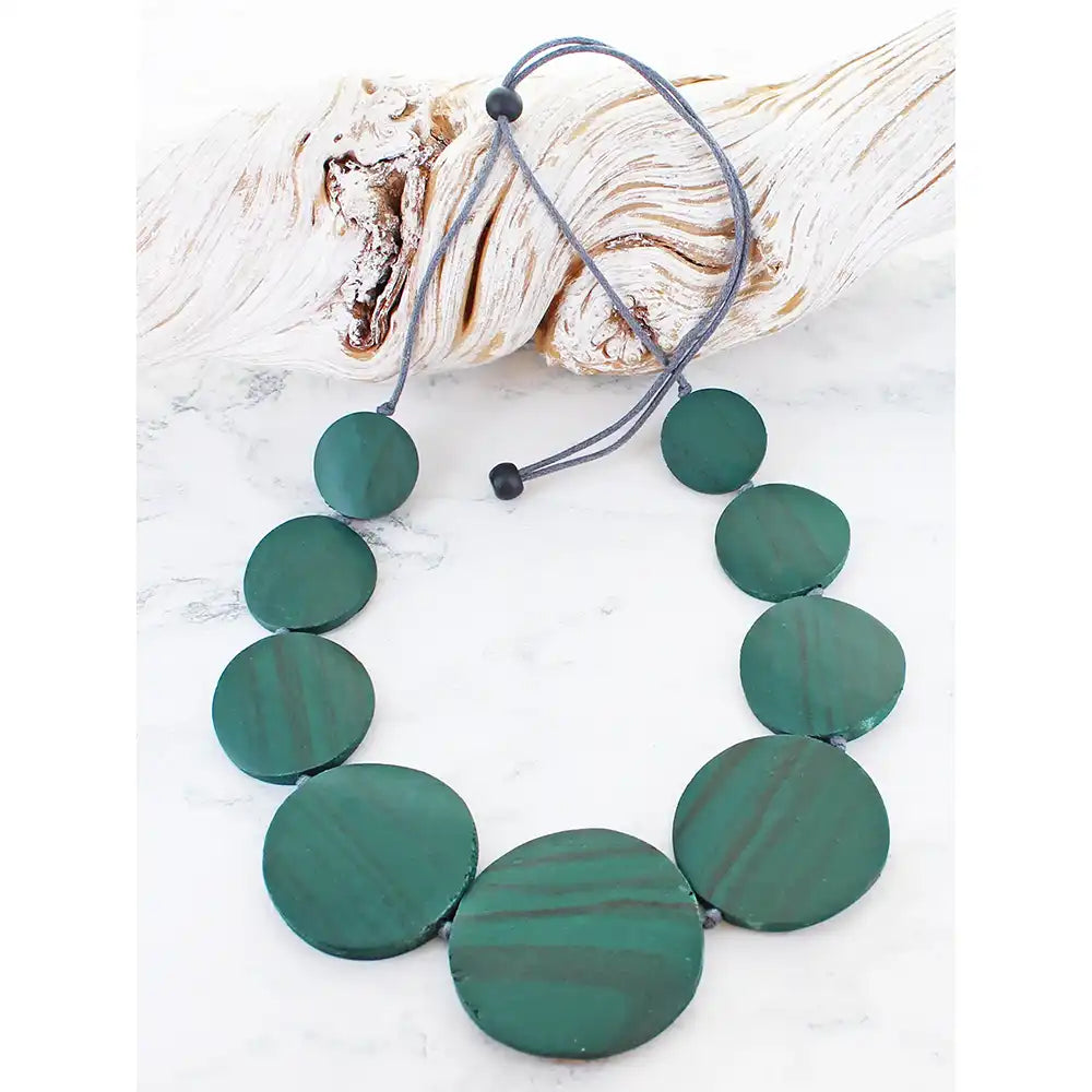 Necklace with green circular beads on a white background