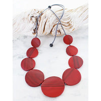 Necklace with red circular beads on a white background