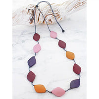 Necklace with colorful leaf-shaped beads on a white marble surface