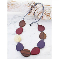 Necklace with wooden teardrop pendants on a white marble surface