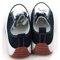 Lace up platform trainers in navy blue. White trim around the base above the black soles. White toe caps. Fabric shoe bodies. Navy blue pull on tabs at the ankles. White stitching detail. Back view showing tan sole part reaching up the back  of the shoes.