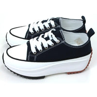 Lace up platform trainers in navy blue. White trim around the base above the black soles. White toe caps. Fabric shoe bodies. Navy blue pull on tabs at the ankles. White stitching detail. Side view.