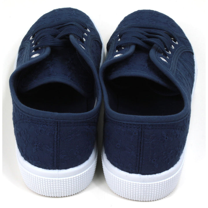 Navy blue plimsol style shoes with flat navy laces with 5 eyes. White rubber soles extending up the sides. Back view. 