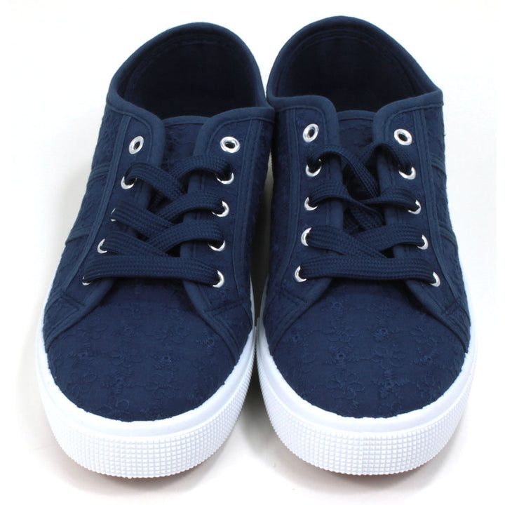 Navy blue plimsol style shoes with flat navy laces with 5 eyes. White rubber soles extending up the sides. Front view. 
