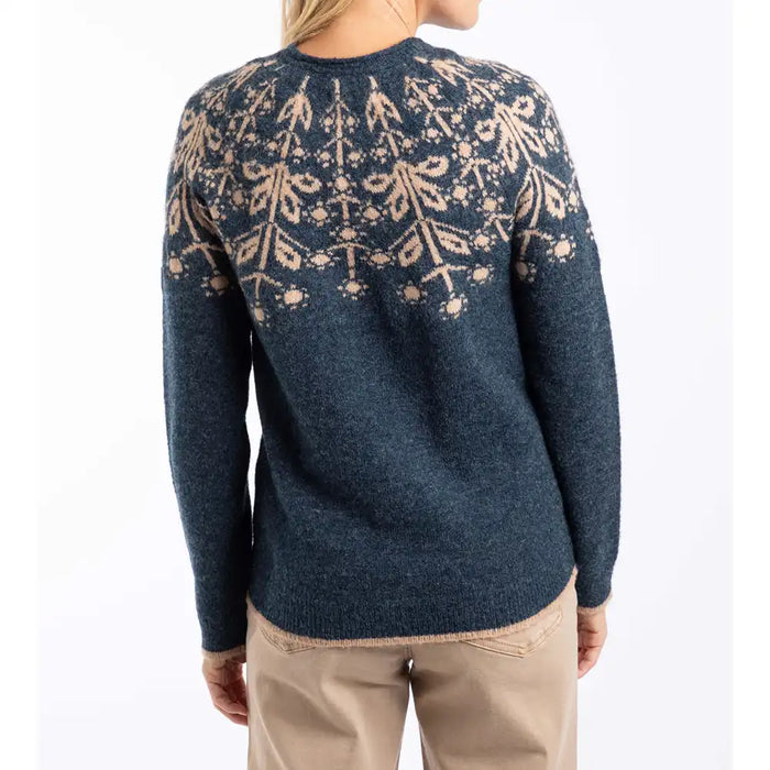 Person wearing a blue sweater with a floral pattern on the back against a white background