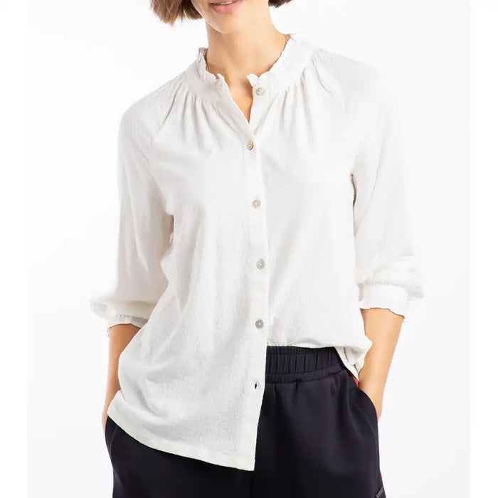 Person wearing a white blouse with rolled-up sleeves on a white background