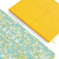 Yellow notebook and blue marbled notebook on a white background