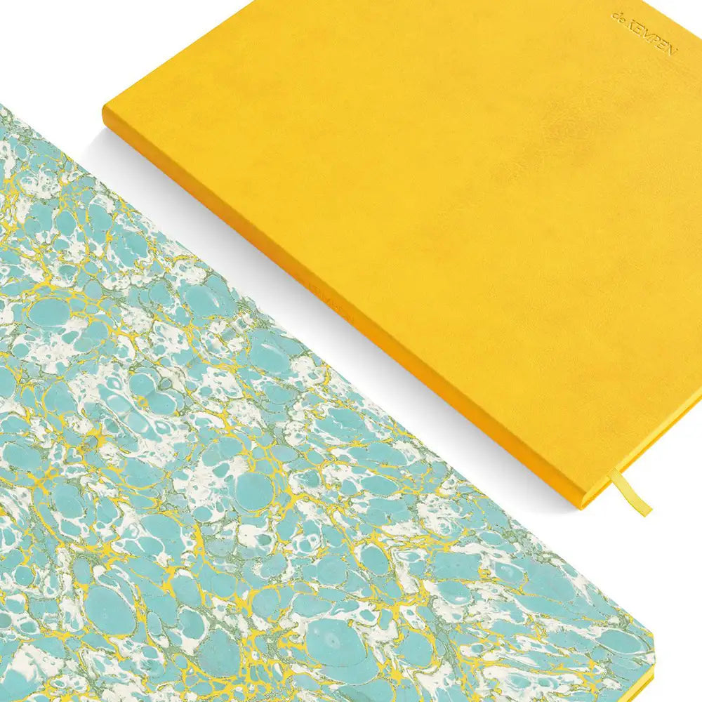 Yellow notebook and blue marbled notebook on a white background