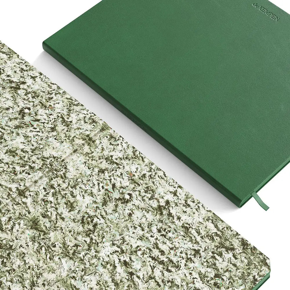 Green notebook on a white surface with a textured green lining beside