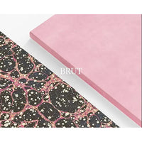 Two sheets of material, one pink showing the outer of the notebook and one with a black and pink pattern, showing the inside cover, on a white background.