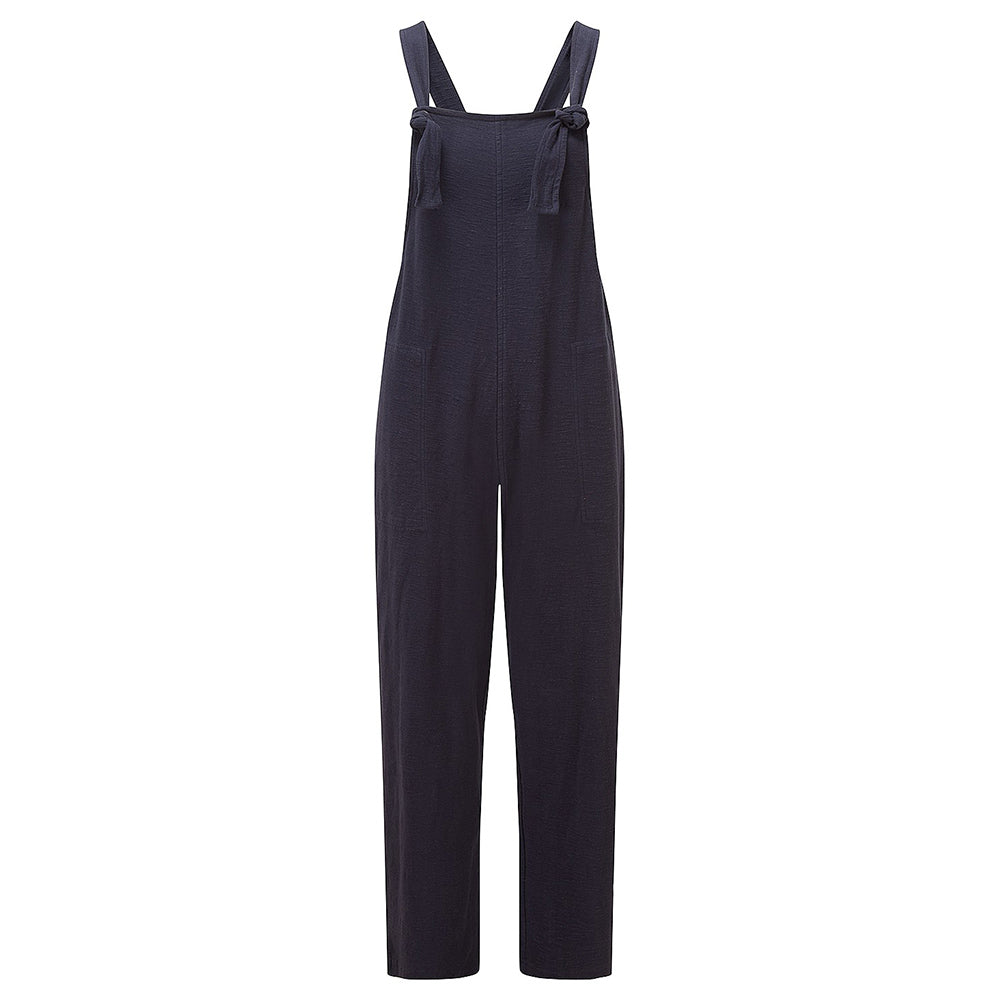 Adini Lucie dugarees in navy blue. Side pockets. Bib is fastened with knots in the straps. Leg length is on the ankle with turn ups. Ghost shot of garment.