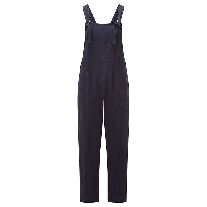 Adini Lucie dugarees in navy blue. Side pockets. Bib is fastened with knots in the straps. Leg length is on the ankle with turn ups. Ghost shot of garment.