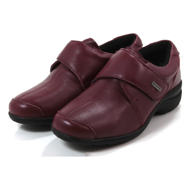 Cotswold Cranham shoes in red. Wrap over strap fastening. Black rubber soles. Angled view