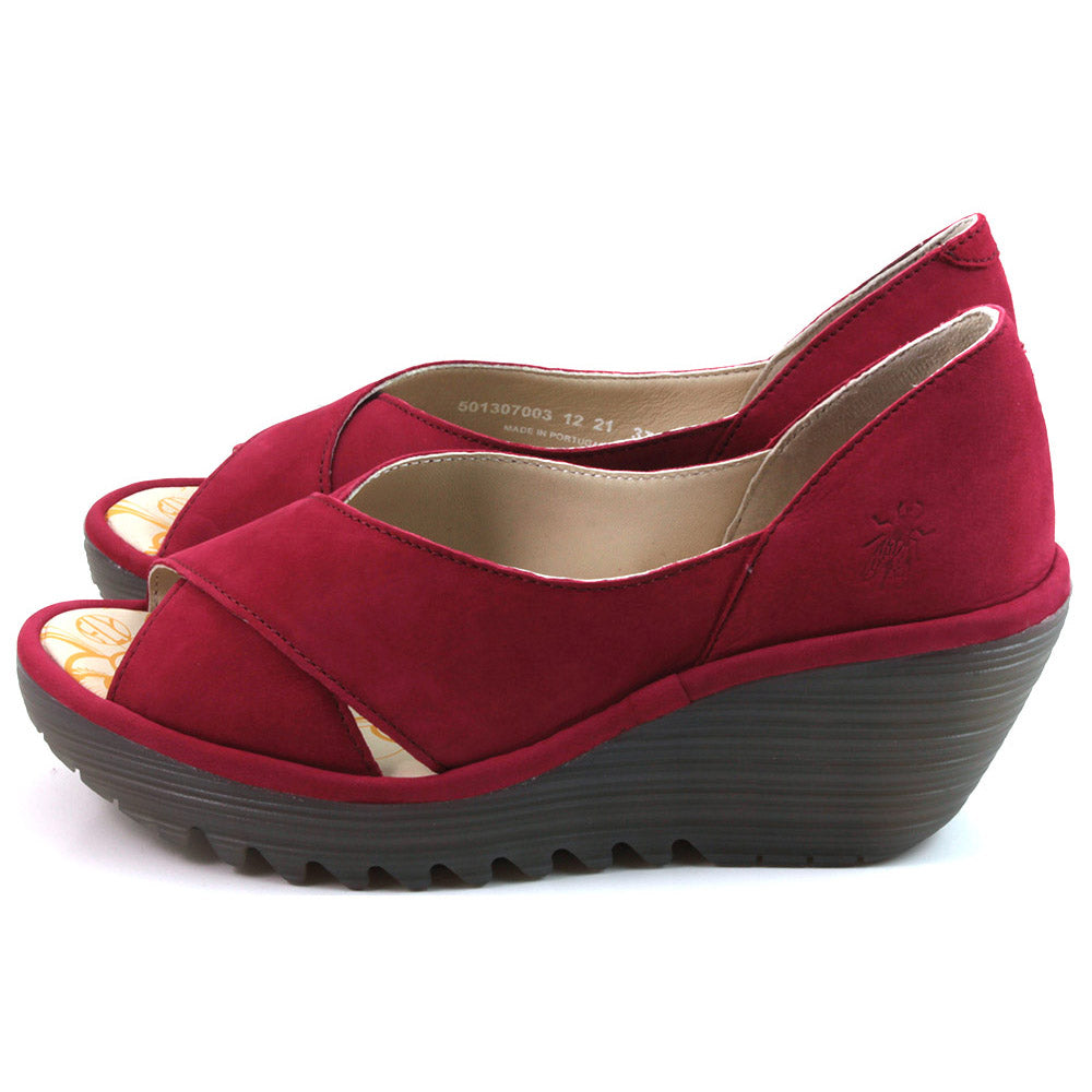 Fly London lipstick red sandals with enclosed heels and crossing straps over the foot. Thick soled with wedge heels. Side view