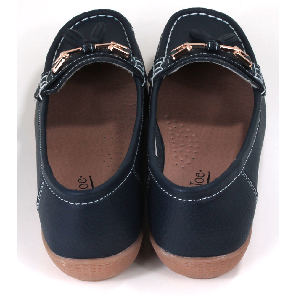 Joe and Jo Nautical moccasin slip on style shoes in dark blue. Gold decorative buckle with double tassels. White stitching. Rubber soles. Back view.