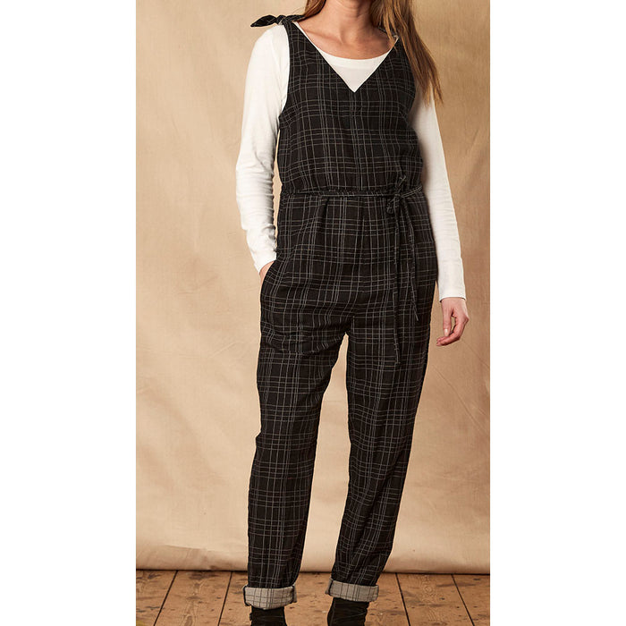 Nomads black checked jumpsuit with trouser turn-ups and secured by tied shoulders. Front close view.