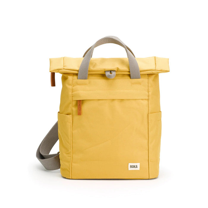 Roka flax yellow backpack. Foldover and zip fastening at the top. External zip fastening pocket. Grey handles and back pack straps. Two water bottle pockets.